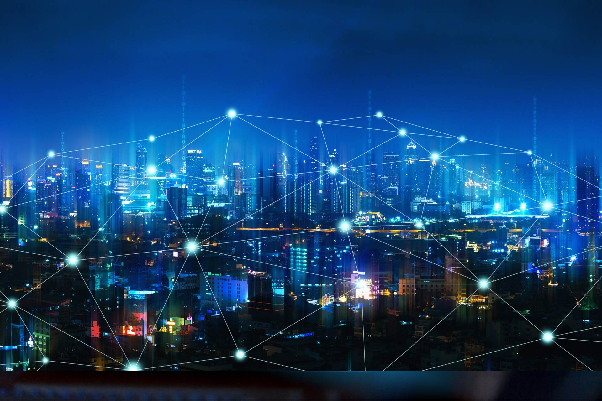 City skyline at night connected by a fibre optic network overlay